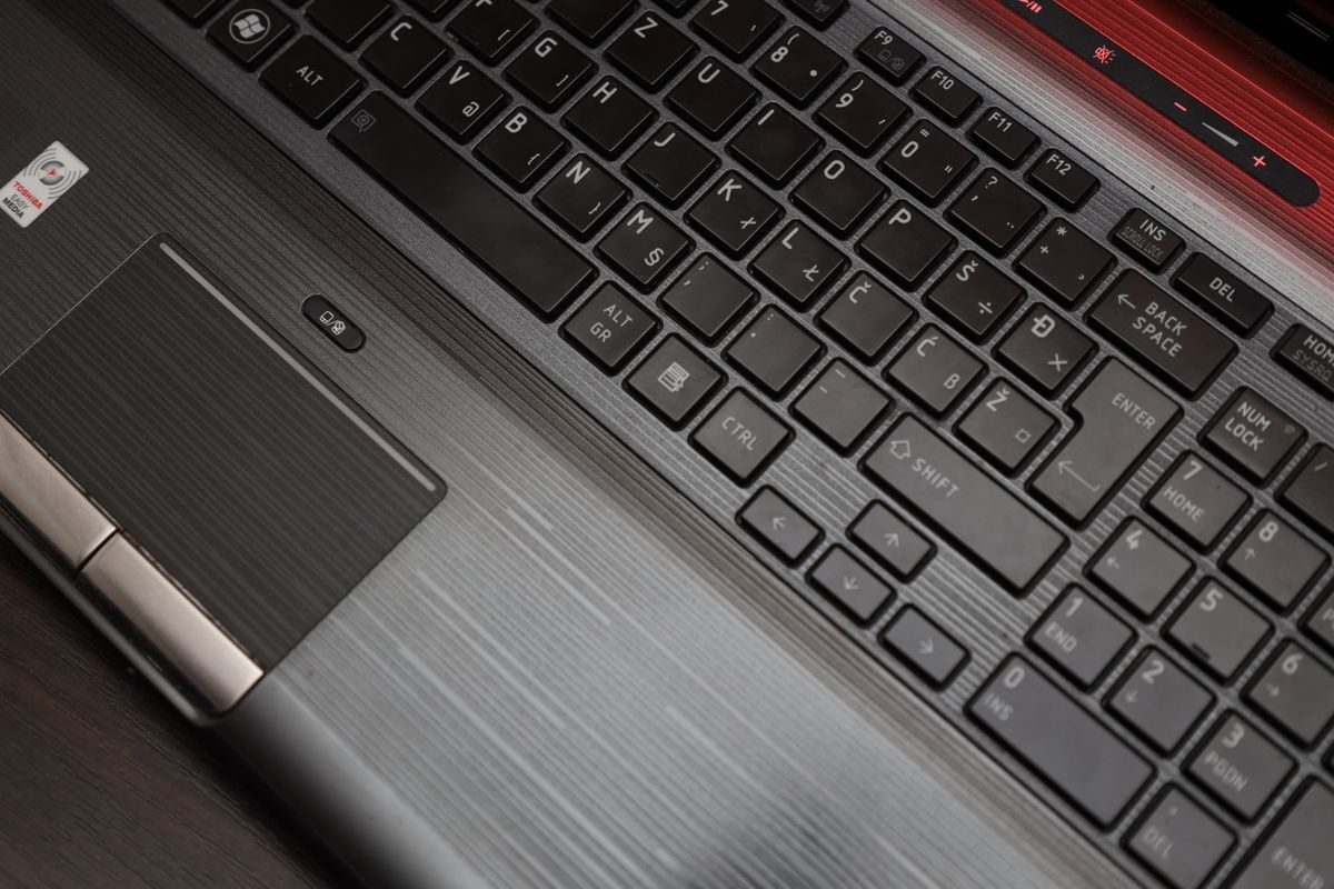 Klawiatura laptopa z touchpadem widziana z góry — demontaż modułu bez uszkodzeń