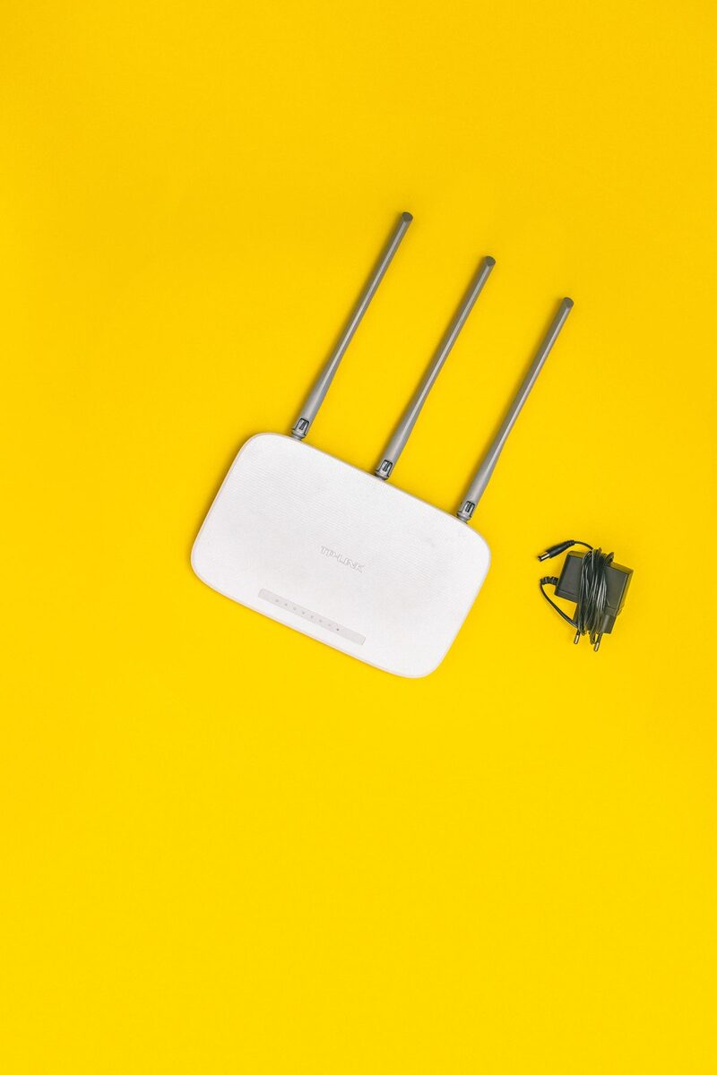 Router Wi-Fi z trzema antenami i zasilaczem — diagnostyka wolnego połączenia